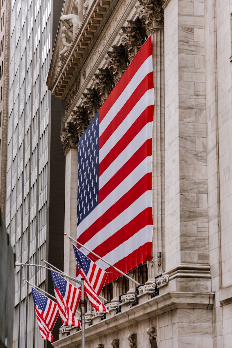 a large american flag hanging from the side of a building