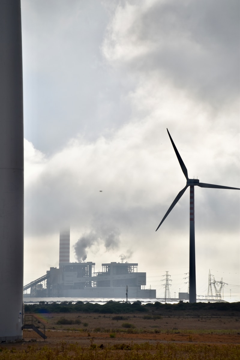 A wind turbine and a factory in the background