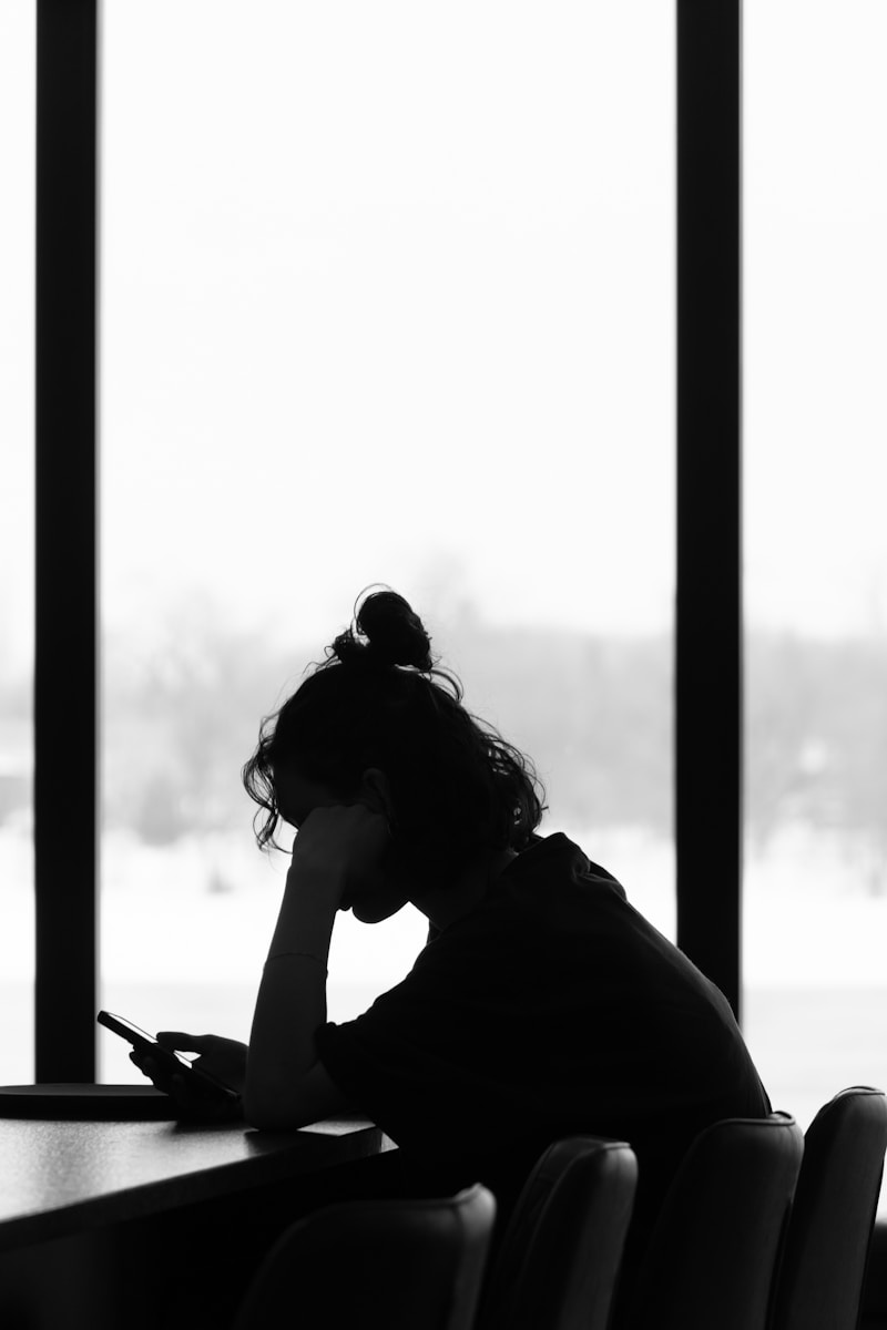 A silhouette of a person on their phone.