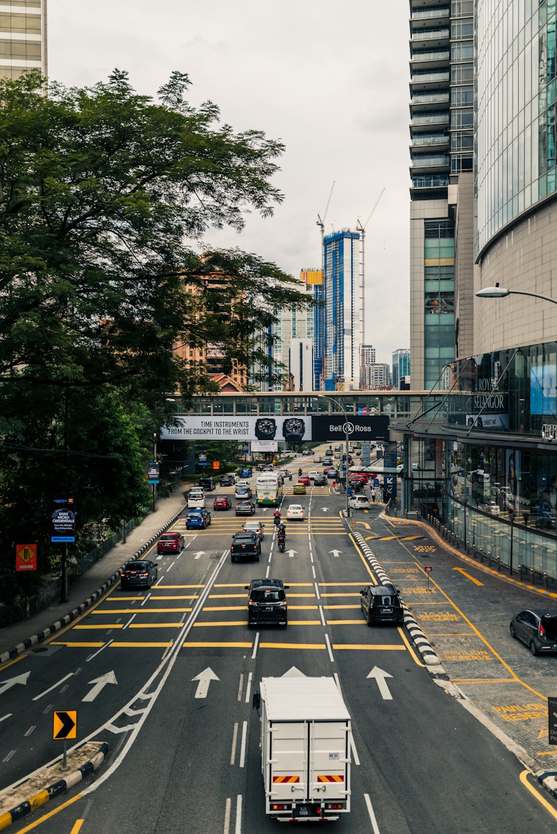 a city street filled with lots of traffic next to tall buildings