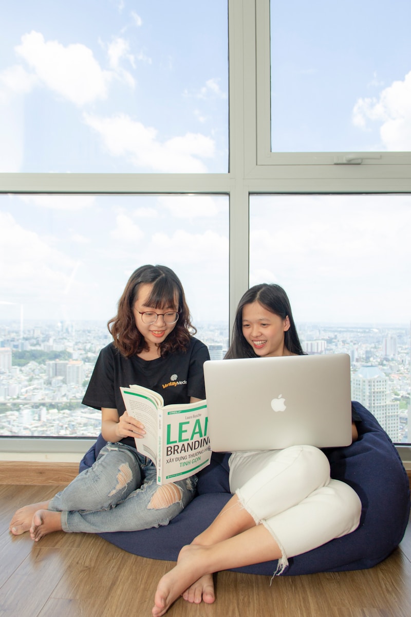 two women sitting on blue sofa