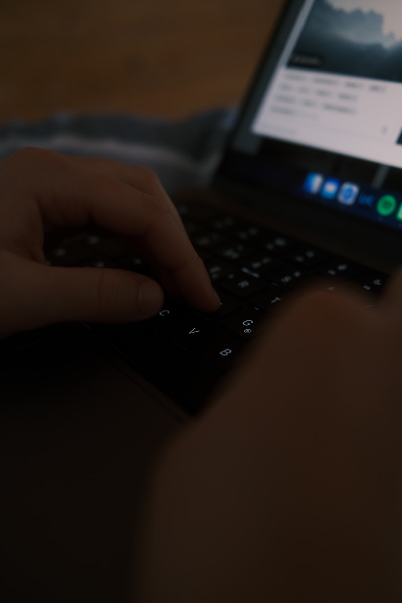 a person is typing on a laptop keyboard