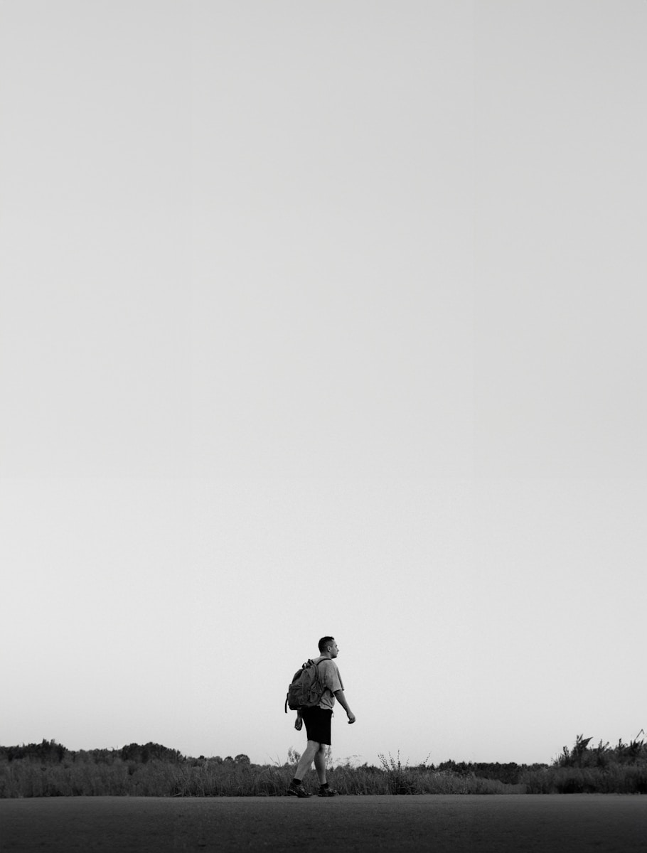 a black and white photo of a person flying a kite