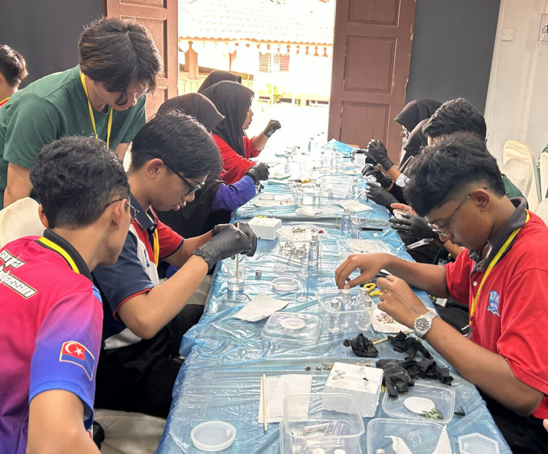Peserta tekun menyiapkan hasil seni mereka dengan dibantu sukarelawan UM