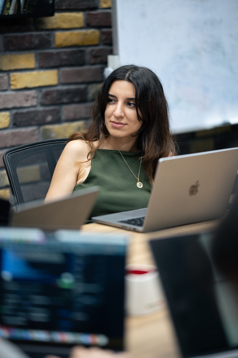 A woman sitting in front of a laptop computer