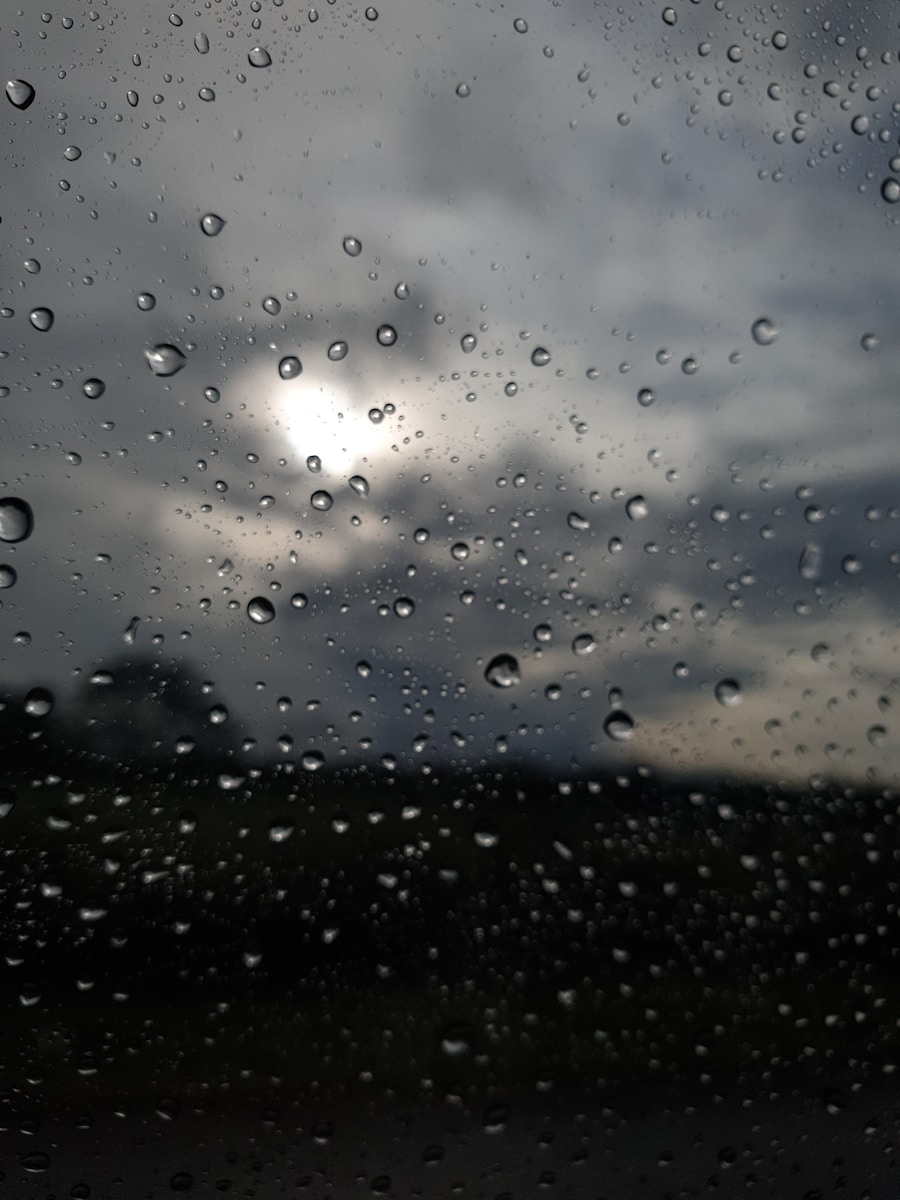 rain drops on a window with a cloudy sky in the background