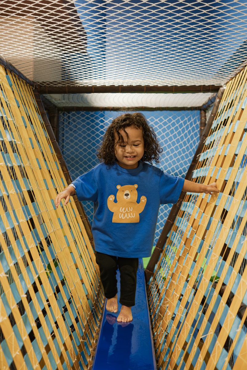 A young child walks on a blue bridge.