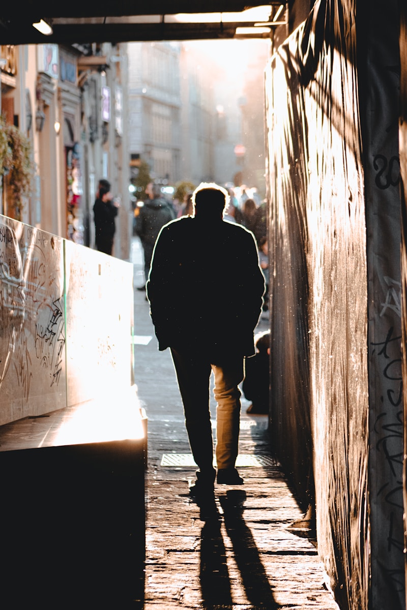 a man walking down a narrow alley way
