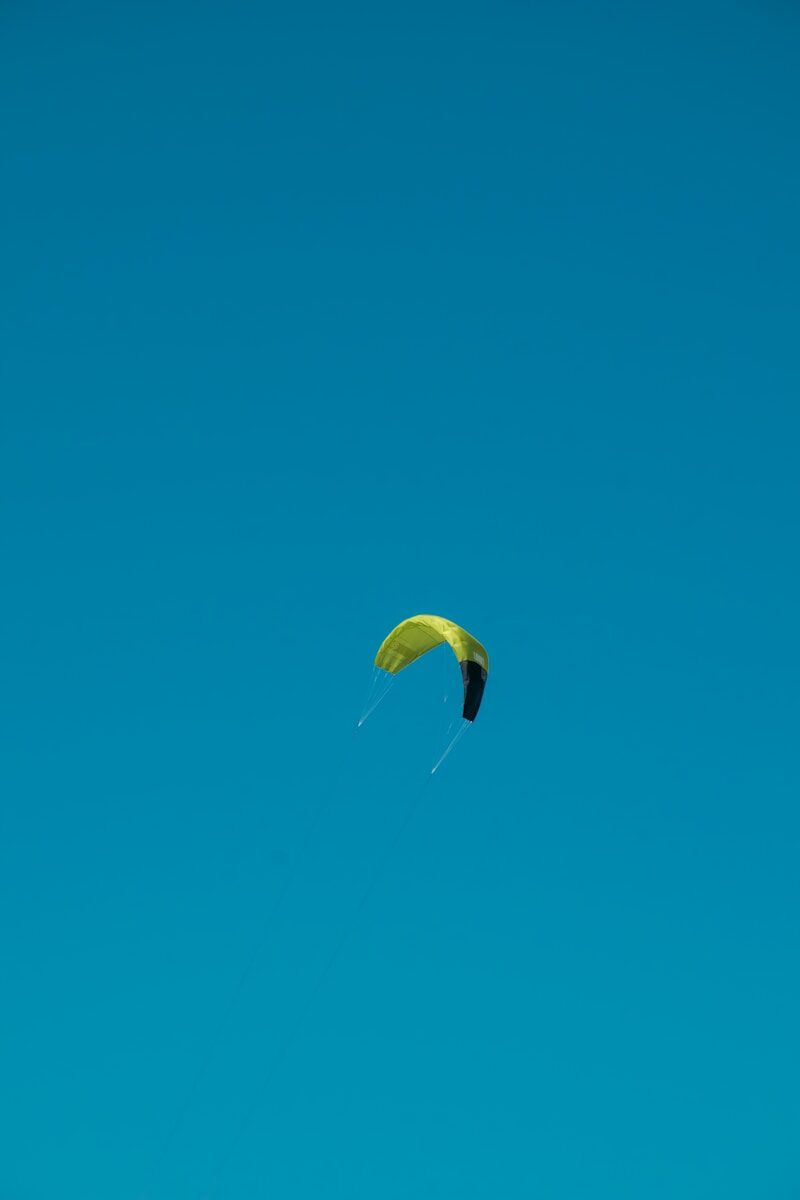 a kite is flying high in the blue sky