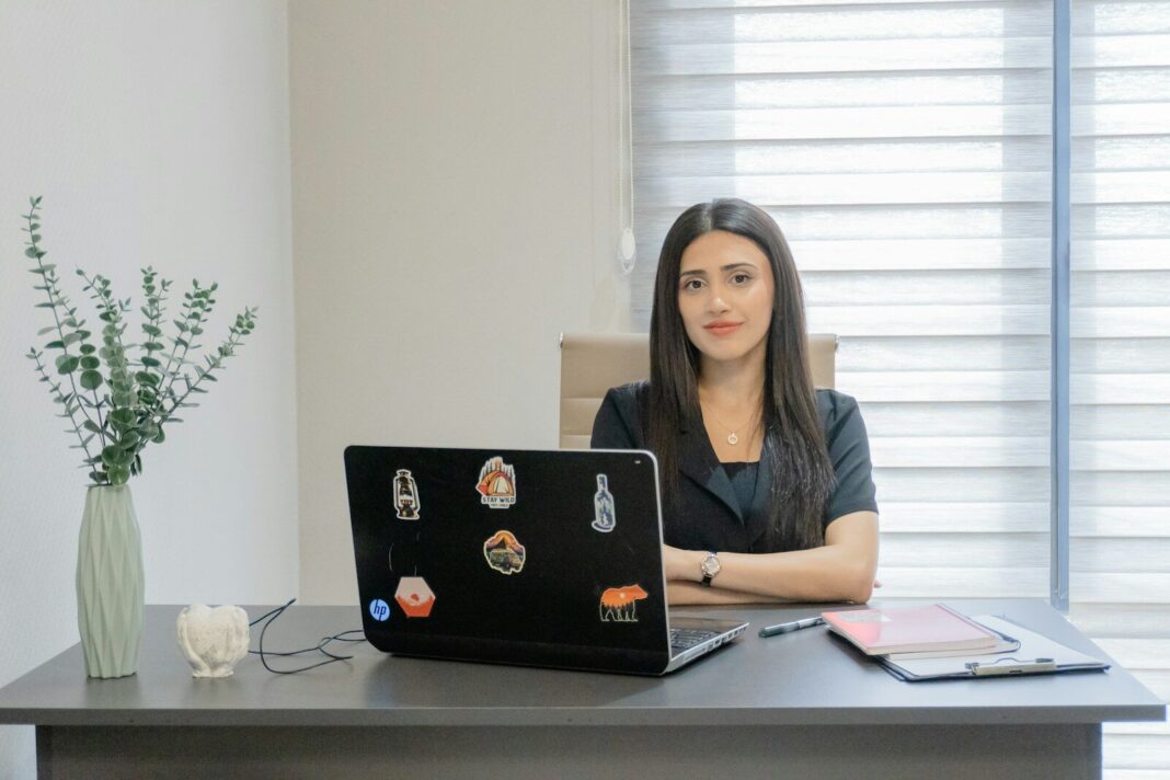 Woman sitting at a desk with a laptop.