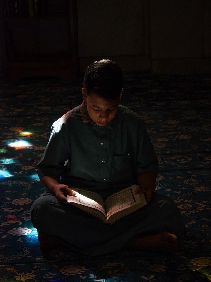 A boy sitting on the floor reading a book
