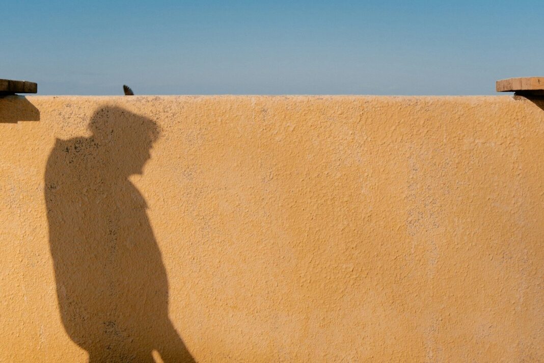 Shadow of a person on a textured wall