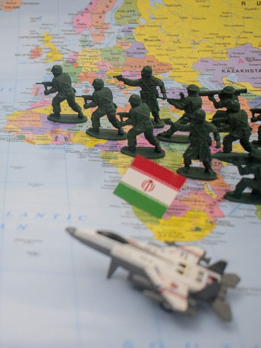 Toy soldiers and jet on world map with iranian flag