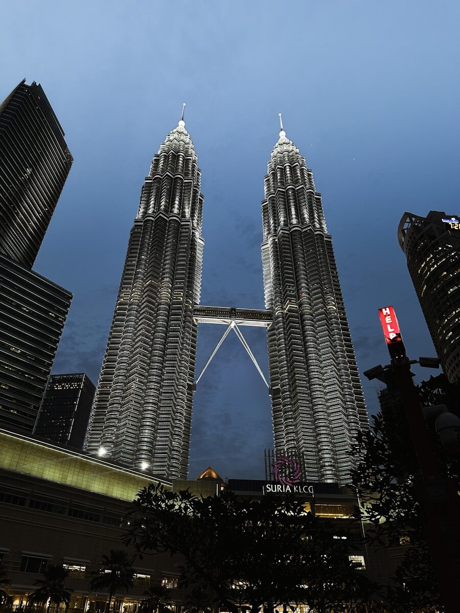 Petronas towers illuminated at dusk with connecting skybridge