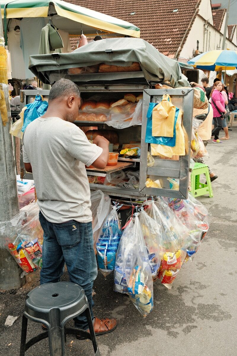 A man standing next to a cart filled with food