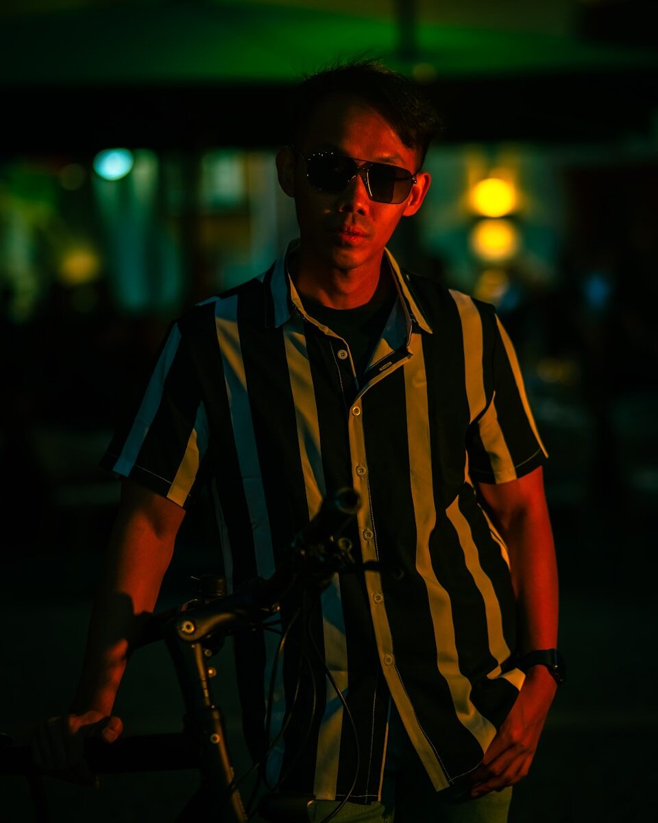Man in striped shirt and sunglasses at night