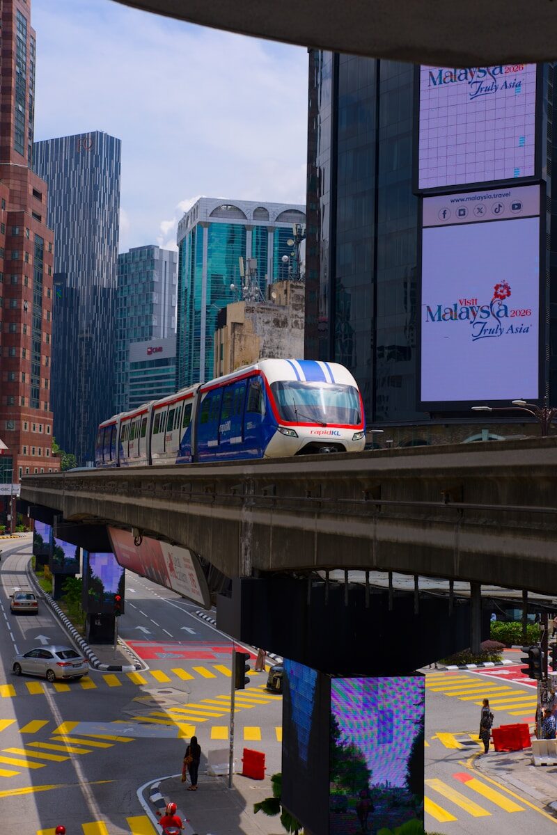 Monorail train travels through a modern city skyline.