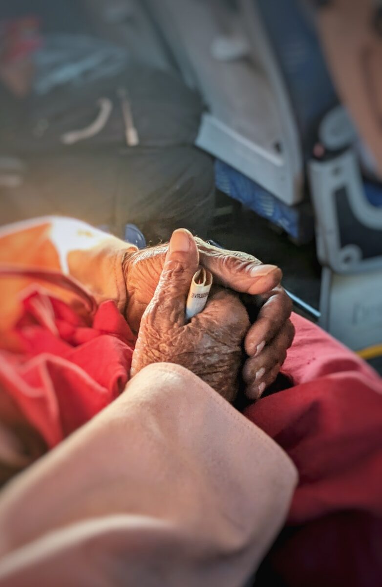 Elderly hands holding a cigarette gently