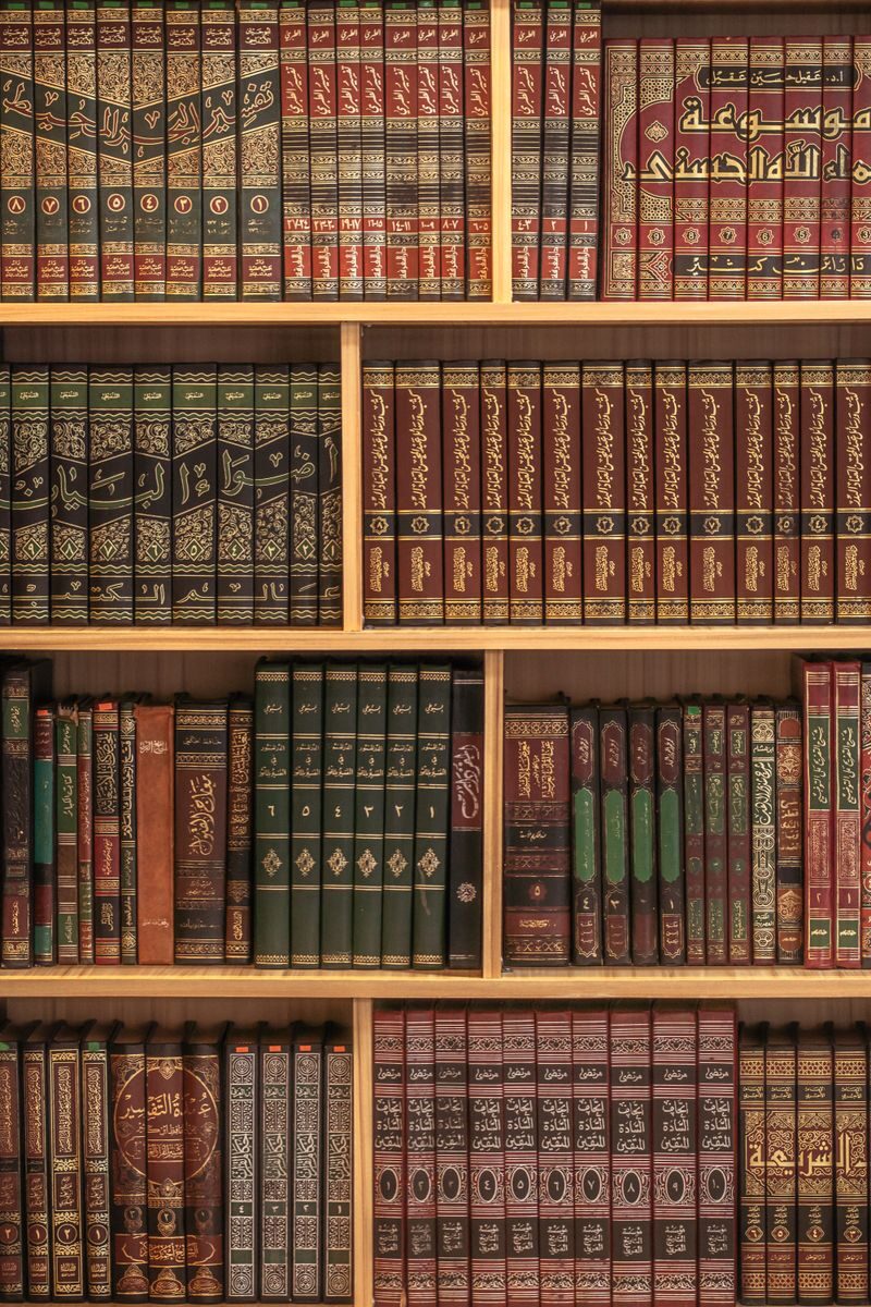 A collection of Islamic books neatly arranged on wooden shelves showcasing rich cultural heritage.