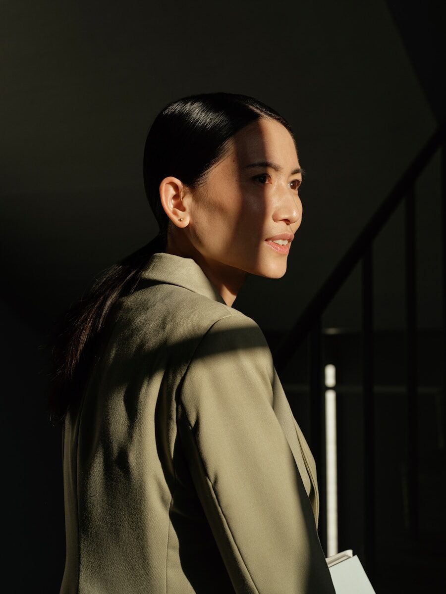 Woman in a blazer with sunlight on her face.