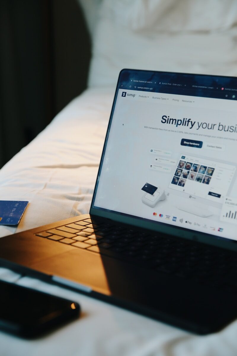 Laptop, phone, and card on a bed