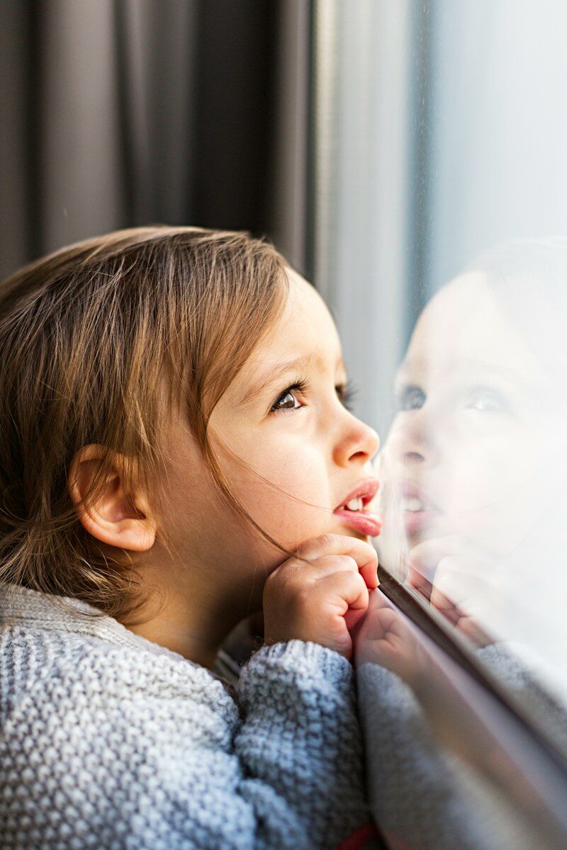girl standing near glass window