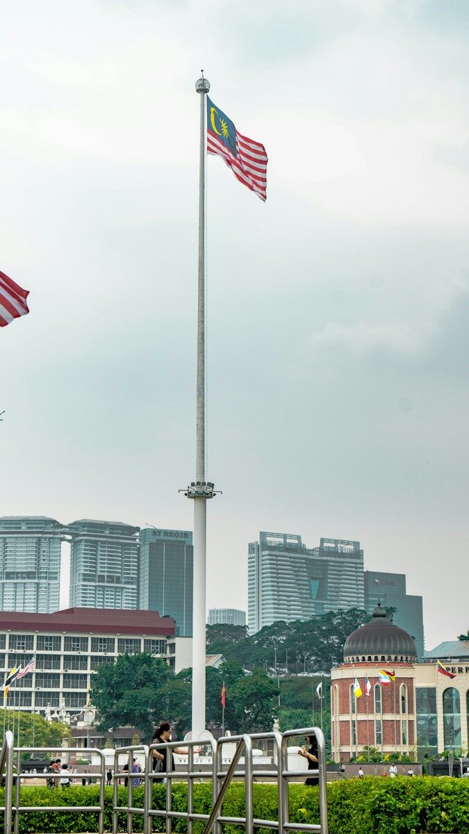 Two american flags flying in front of a city skyline