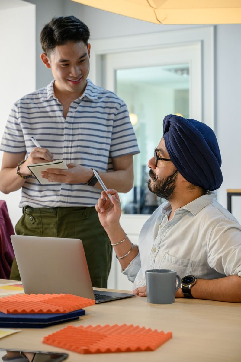 Two colleagues discuss a project in a modern office setting, fostering teamwork.