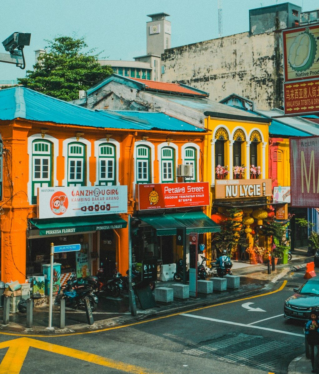 Colorful shophouses with orange and yellow facades on Petaling Street in Kuala Lumpur
